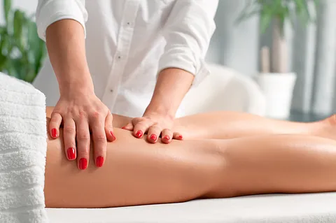 manos de fisioterapeuta sobre pierna de mujer